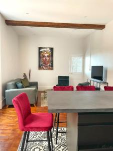 a living room with red chairs and a couch at Charming appartement with a view of the Saone in Mâcon