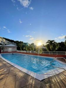 una grande piscina con il sole sullo sfondo di Régal de la Baie a La Trinité