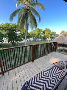 a deck with a palm tree and a hammock on it at Hotel Gavia - Rio y Mar in Palomino