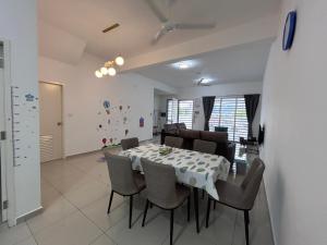 - une salle à manger avec une table et des chaises dans l'établissement Cool Gateaway Seremban Homestay, à Labu