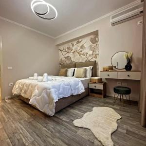 een slaapkamer met een groot bed en een spiegel bij Comfort Apartment Tirane in Tirana