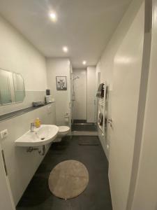 a white bathroom with a sink and a shower at Ferienwohnungen Allgäu Zimmer in Memmingen