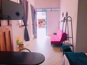 een woonkamer met een tafel en een roze bank bij Aloja-T en Apartaloft amoblado en Jericó in Jericó
