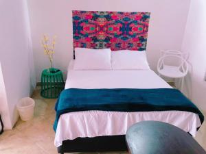 een slaapkamer met een bed met een rode en blauwe deken bij Aloja-T en Apartaloft amoblado en Jericó in Jericó