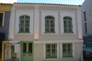 un edificio bianco con porte e finestre verdi di HOUSE KA TEKKE 2 a Çanakkale