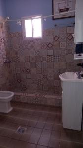 a bathroom with a toilet and a sink and a window at Sanguinetti in Colón