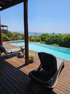 a chair sitting on a deck next to a swimming pool at Chilled Vibes in Ponta Mamoli