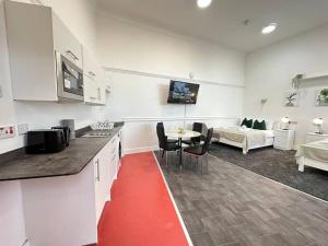 a kitchen and living room with a table and a couch at Modern Spacious Flat in Dudley Area in Birmingham