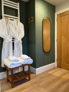 een kamer met een spiegel en een tafel met handdoeken bij Allium in Tenby