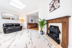 a living room with a couch and a fireplace at Wembley Stadium 5 Bed House in Wembley