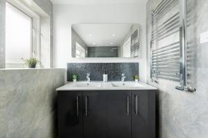 a bathroom with a sink and a mirror at Wembley Stadium 5 Bed House in Wembley