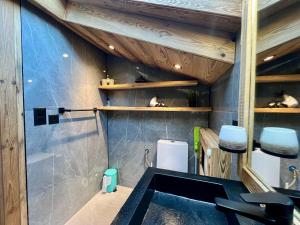 La salle de bains est pourvue d'un lavabo et de plafonds en bois. dans l'établissement Attique - vue plongeante sur le lac de la Moubra, à Crans-Montana