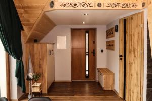 a hallway with a wooden door and wooden floors at Domek Parzenica Nowy Targ in Nowy Targ