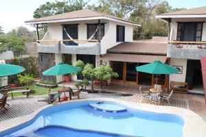 a resort with a swimming pool and a house at Galapagos Cottages in Puerto Ayora