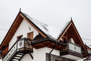 een huis met een met sneeuw bedekt dak bij Domek Parzenica Nowy Targ in Nowy Targ