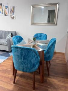 einen Tisch mit zwei blauen Stühlen und einem Spiegel in der Unterkunft Departamento de Estreno - cerca a la Playa in Lima