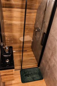 La salle de bains est pourvue d'une douche avec un tapis vert. dans l'établissement Domek Parzenica Nowy Targ, à Nowy Targ