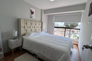 利馬的住宿－Departamento de Estreno - cerca a la Playa，一间卧室设有一张大床和一个窗户。