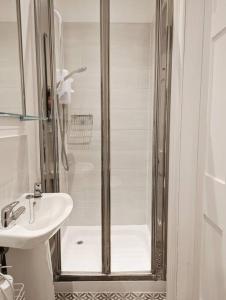 a white bathroom with a shower and a sink at Central 4-bed House, 10 min Walk to Sights in Bath