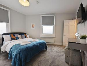 a bedroom with a bed with a blue blanket at Central 4-bed House, 10 min Walk to Sights in Bath