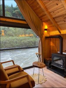 a living room with a fireplace and a chair at Serinle Bungalow in Rize