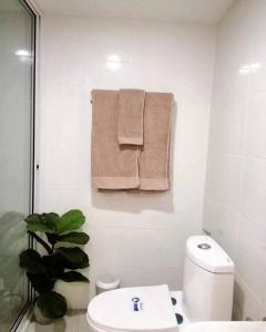 ein Bad mit WC und Handtüchern an der Wand in der Unterkunft Nimman Mountain View in Chiang Mai