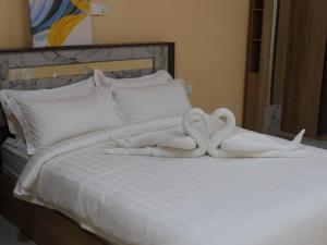 ein Bett mit zwei Schwänen aus Handtüchern in der Unterkunft Tropical stay Thulusdhoo in Thulusdhoo