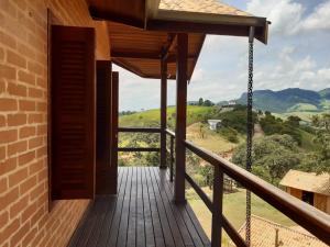 a wooden deck with a view of the mountains at Chalé Recanto Lobo Guará in Gonçalves