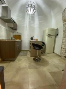a kitchen with a chair and a refrigerator at De Cristoforis in Terlizzi