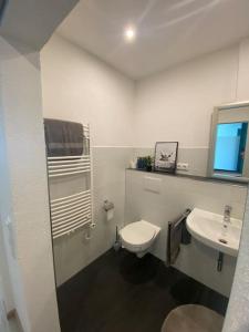 a white bathroom with a toilet and a sink at Ferienwohnung Sonnenblume in Memmingen
