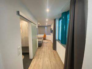 a hallway leading to a room with a couch and a room with blue walls at Ferienwohnung Sonnenblume in Memmingen