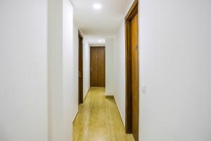 a hallway with white walls and a wooden door at 79600 The Premium Villa in New Delhi