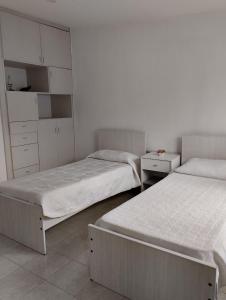 two beds in a room with white walls at Departamento Céntrico in Esquel