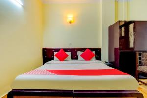 a bedroom with a large bed with red pillows at OYO Hotel Delhi Darbar in New Delhi