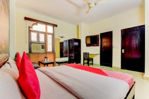 a bedroom with a large bed with red pillows at OYO Hotel Delhi Darbar in New Delhi