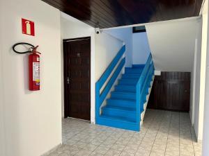 a stairway with a blue staircase in a house at Kyros Pousada in Maceió