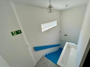 uma casa de banho com paredes azuis e brancas e um urinol em Kyros Pousada em Maceió