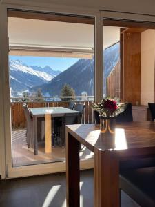 a balcony with a table and a view of a mountain at WEF Appartement in Davos