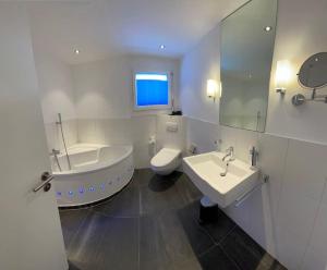 a bathroom with a tub and a toilet and a sink at WEF Appartement in Davos