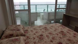 1 dormitorio con cama y vistas al océano en TERRAZZO ONDINA, en Salvador