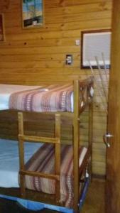 a room with two bunk beds in a cabin at Yvyra Lodge in San Ignacio