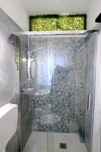 une douche avec une porte vitrée dans une salle de bain dans l'établissement SIKELIA Apartment, à Caltagirone