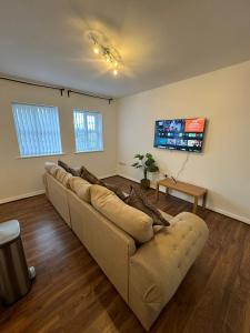 a living room with a couch and a flat screen tv at Manchester Cosy flat close to City Centre and City stadium in Manchester
