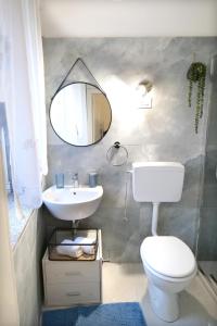 uma casa de banho com um WC branco e um espelho. em SIKELIA Apartment em Caltagirone