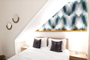 um quarto com uma cama branca e uma parede verde e branca em SIKELIA Apartment em Caltagirone