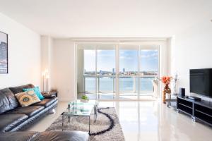 a living room with a couch and a large window at Golden Bay 805 in Miami Beach
