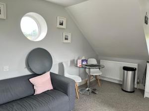 ein Wohnzimmer mit einem Sofa und einem Tisch in der Unterkunft The Annexe in Bath