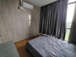ein Schlafzimmer mit einem Bett und einem großen Fenster in der Unterkunft Samarahan Staycation 2 bedrooms in Kampong Samawang