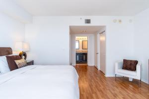 a bedroom with a white bed and a white chair at Golden Bay 805 in Miami Beach +47 photos