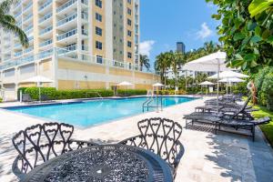 a pool with chairs and a table and a building at Golden Bay 805 in Miami Beach